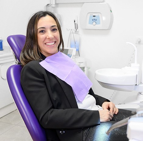 Woman sitting in dental chair and smiling