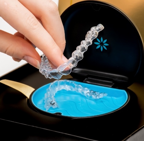 Person placing an Invisalign clear aligner into its storage case
