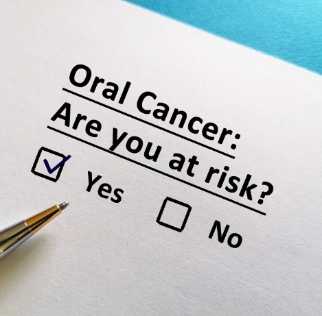 Pen checking off yes box on form that says oral cancer are you at risk